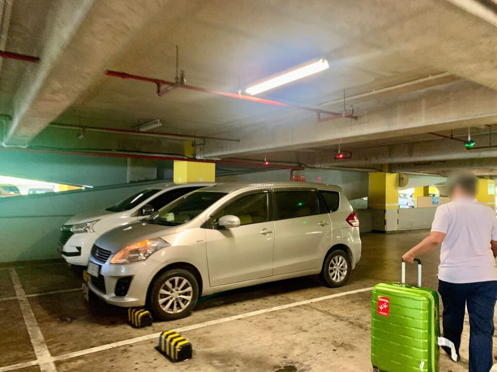 Following a driver to the airport parking lot for a Bali airport taxi 2026 pickup.
